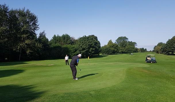 Photograph of a man playing golf