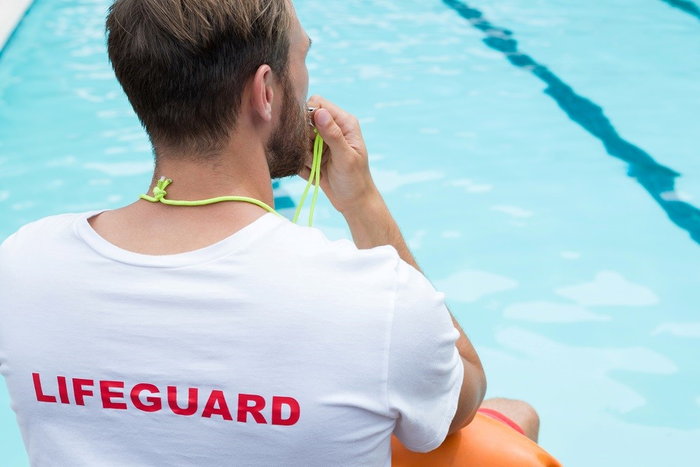 A photograph of a lifeguard at a swimming pool